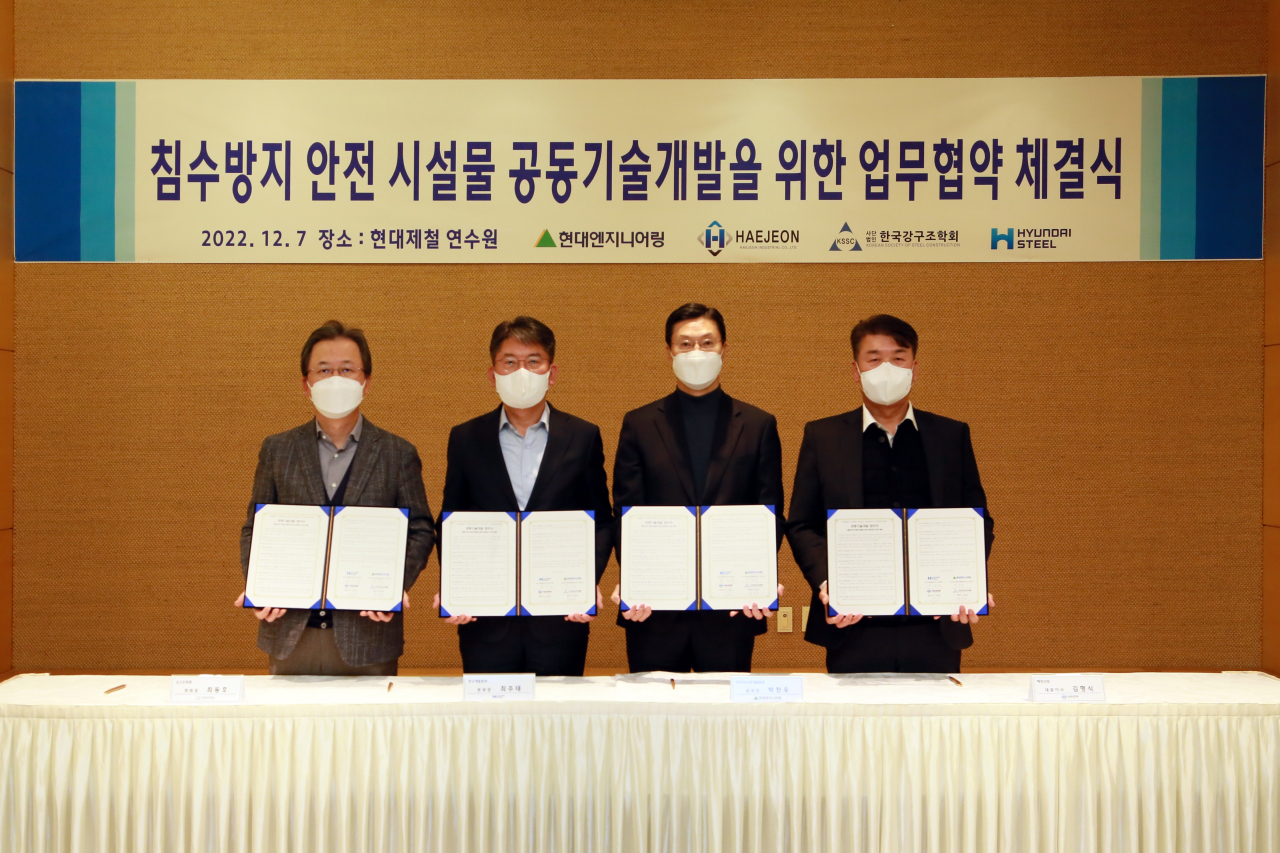 Representatives from Hyundai Steel, Hyundai Engineering, Haejeon Industry and the Korean Society of Steel Construction pose after signing a memorandum of understanding at the steel maker's steel mill in Dangjin, South Chungcheong Province, Wednesday.