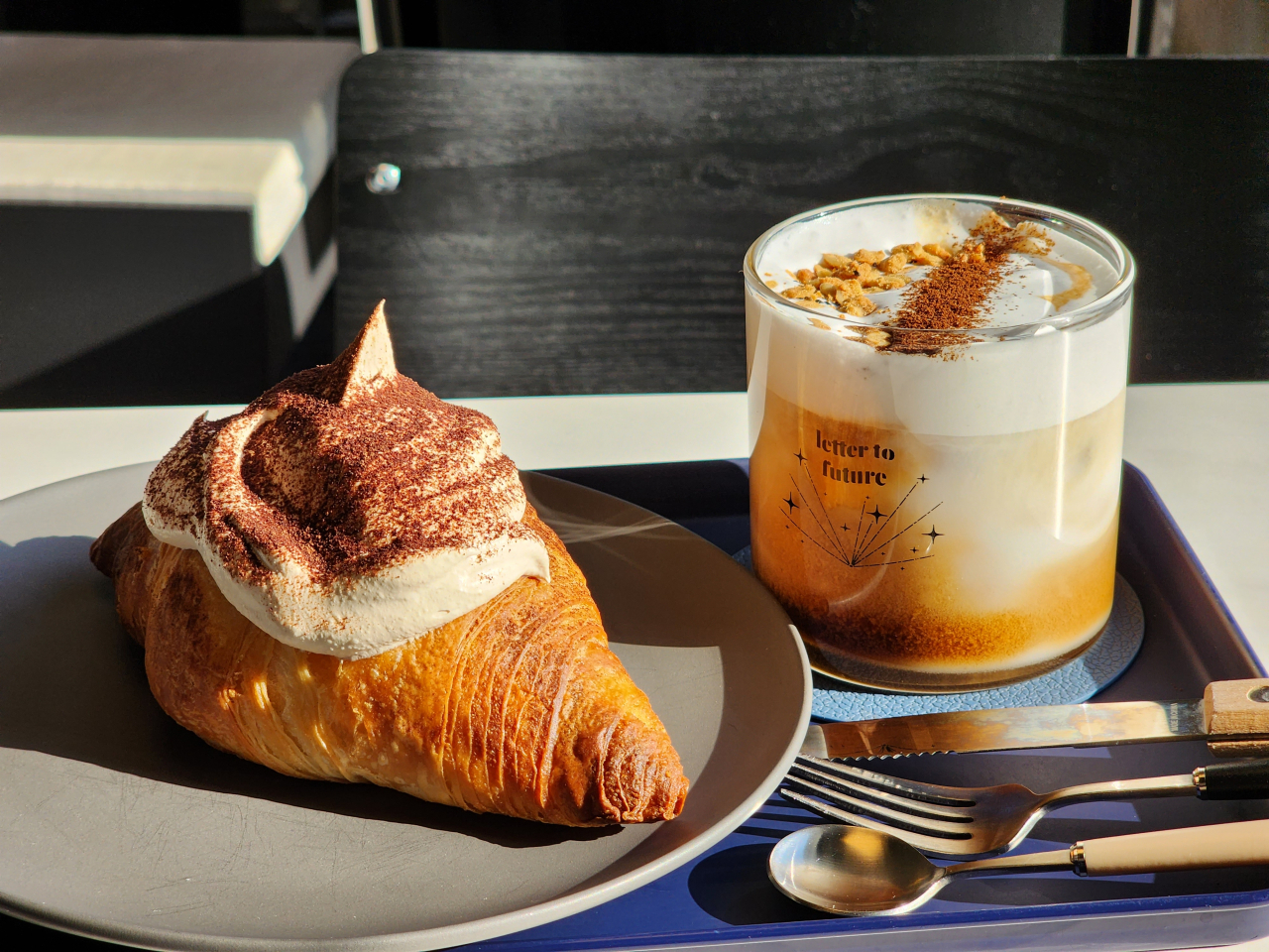 A croissant with mocha cream (left) and a cup of latte with almond cream (Hwang Dong-hee/The Korea Herald)