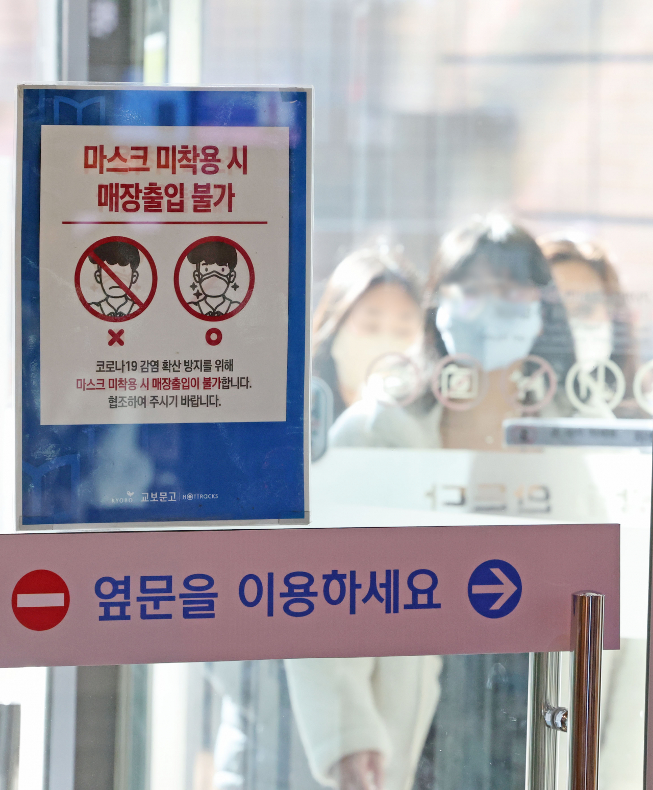 A poster on the entrance door to a bookstore in Seoul instructs visitors to wear a face mask on Wednesday. (Yonhap)