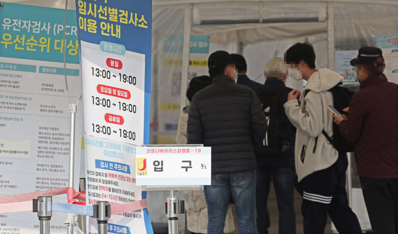 People line up at a coronavirus testing center near Seoul Station on Friday. (Yonhap)