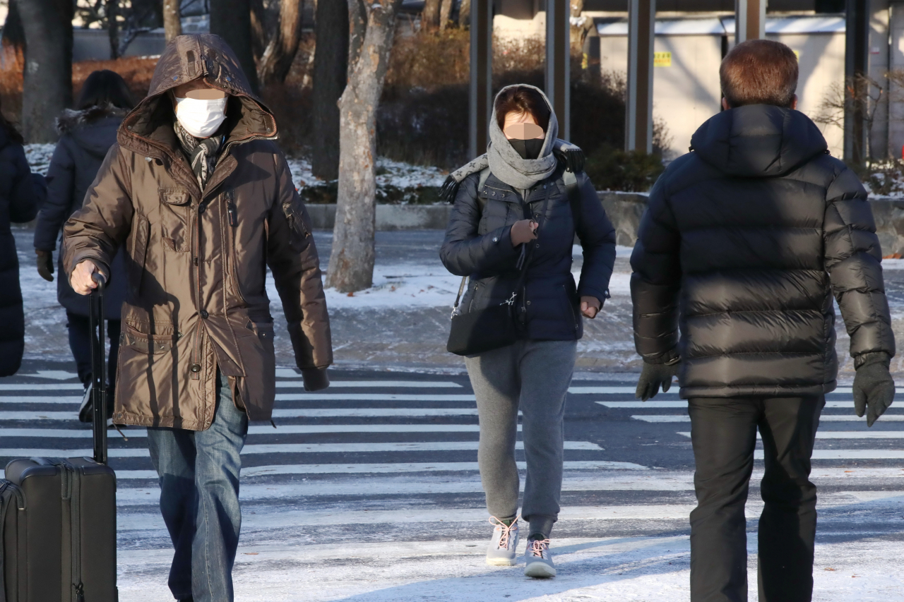 People are heading to work in Dunsan-dong, Seo-gu, Daejeon, wrapped in thick coats and winter items on the morning of Wednesday, when a cold wave advisory was issued. (Yonhap)