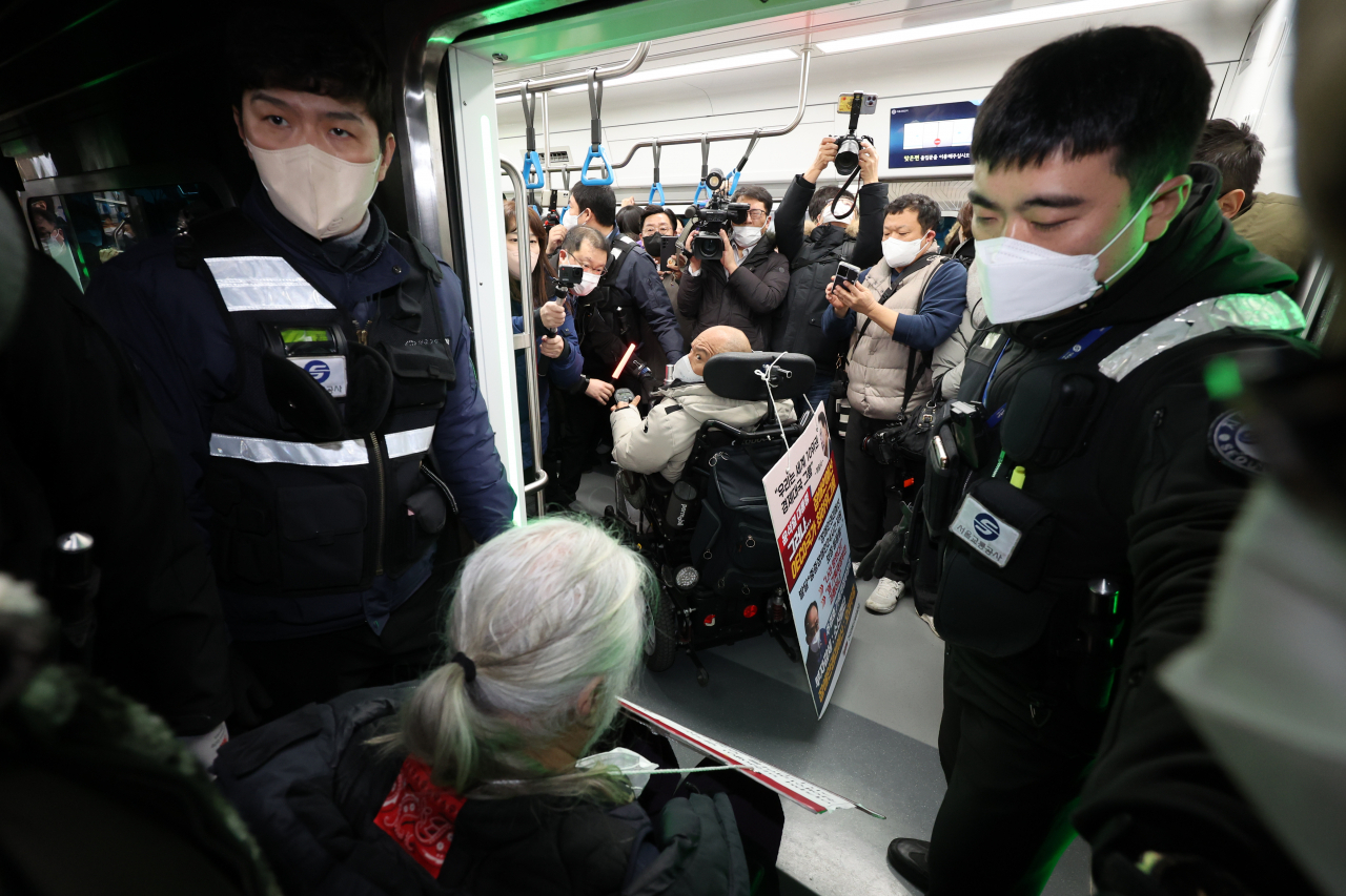 Members of the Solidarity Against Disability Discrimination board a subway train at Samgakji Station in Seoul on Tuesday, as part of their demonstration demanding an increased government budget to protect the rights of people with disabilities. (Yonhap)