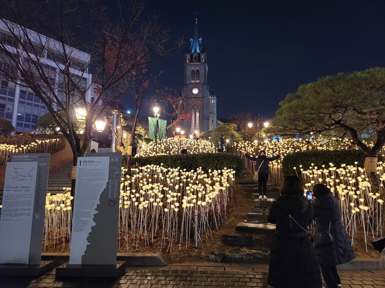 Visitors take photographs at Myeongdong Cathedral, decorated with lights in celebration of Christmas, in Seoul, Monday. (Park Yuna/The Korea Herald)