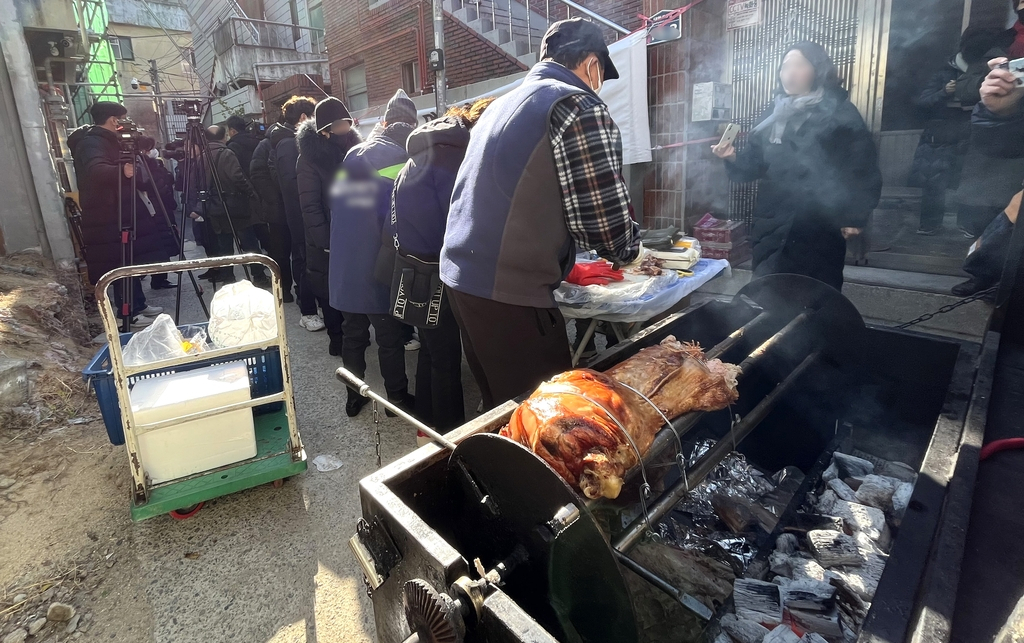 Residents of Daehyeon-dong in Daegu in opposition to the construction of a mosque in the neighborhood on Thursday cook a whole pig near the construction site. (Yonhap)
