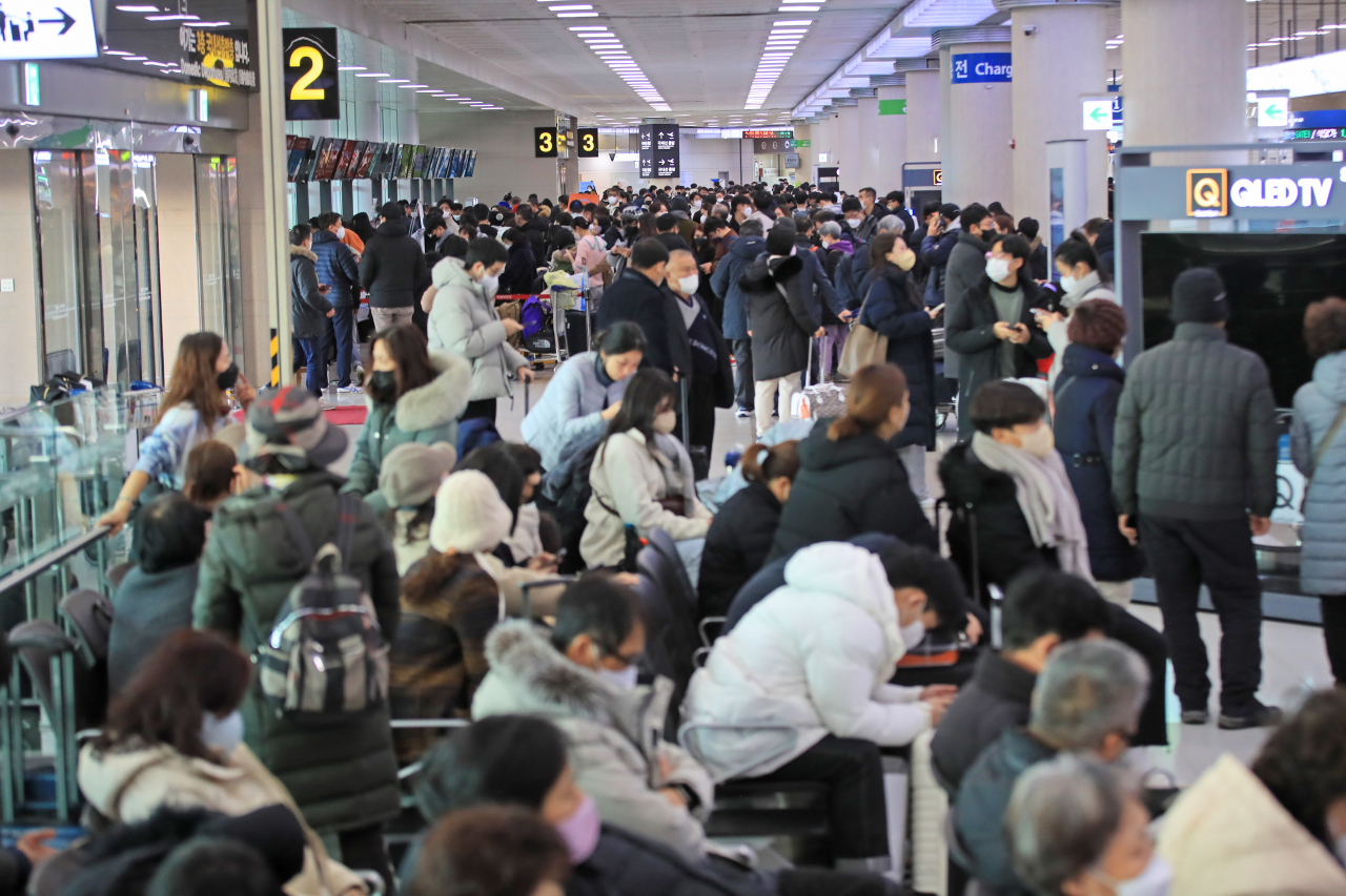 Departure gate at Jeju International Airport on Sunday is crowded with passengers waiting for their flights amid a heavy snow warning. (Yonhap)