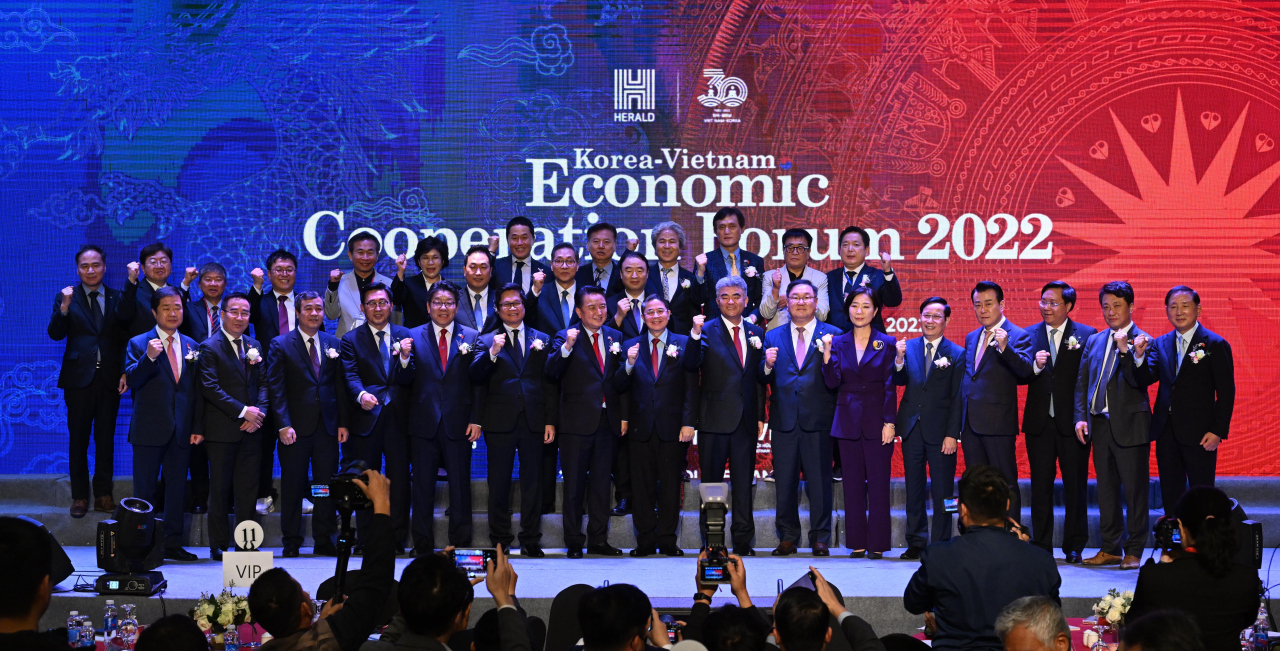 High-ranking government officials and political and business leaders of both countries pose for a photo during the Korea-Vietnam Economic Cooperation Forum held in Hanoi, Vietnam, Friday. Key figures in the front row include: Ngo Dong Hai, secretary of the Thai Binh Provincial Party Committee (third from left); Choi Jin-young, CEO of The Korea Herald (fifth from left); Vu Tien Loc, head of the Vietnam-Korea Friendship Association (sixth from left); Kim Young-hwan, governor of North Chungcheong Province (seventh from left); Nguyen Duc Hai, vice chairman of the National Assembly of Vietnam (eighth from left); Jung Won-ju, chairman of Herald Corp. and Daewoo E&C (ninth from left); the Democratic Party of Korea’s Rep. Kim Tae-nyeon, who heads Korea-Vietnam Parliamentary Friendship Group (10th from left); Oh Young-ju, Korean Ambassador to Vietnam (11th from left); Pham Tan Cong, chairman of the Vietnam Chamber of Commerce and Industry (12th from left); Ko Sang-goo, president of K&K Global Trading (13th from left); and Tran Duy Dong, deputy minister of Planning and Investment of Vietnam (14th from left). (Park Hae-mook/The Korea Herald)