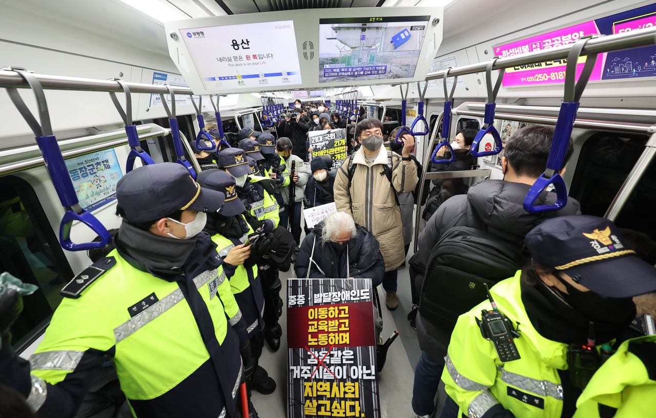 Solidarity Against Disability Discrimination activists hold a protest on a train passing through Yongsan Station on Seoul Subway Line No. 1., Monday. (Yonhap)