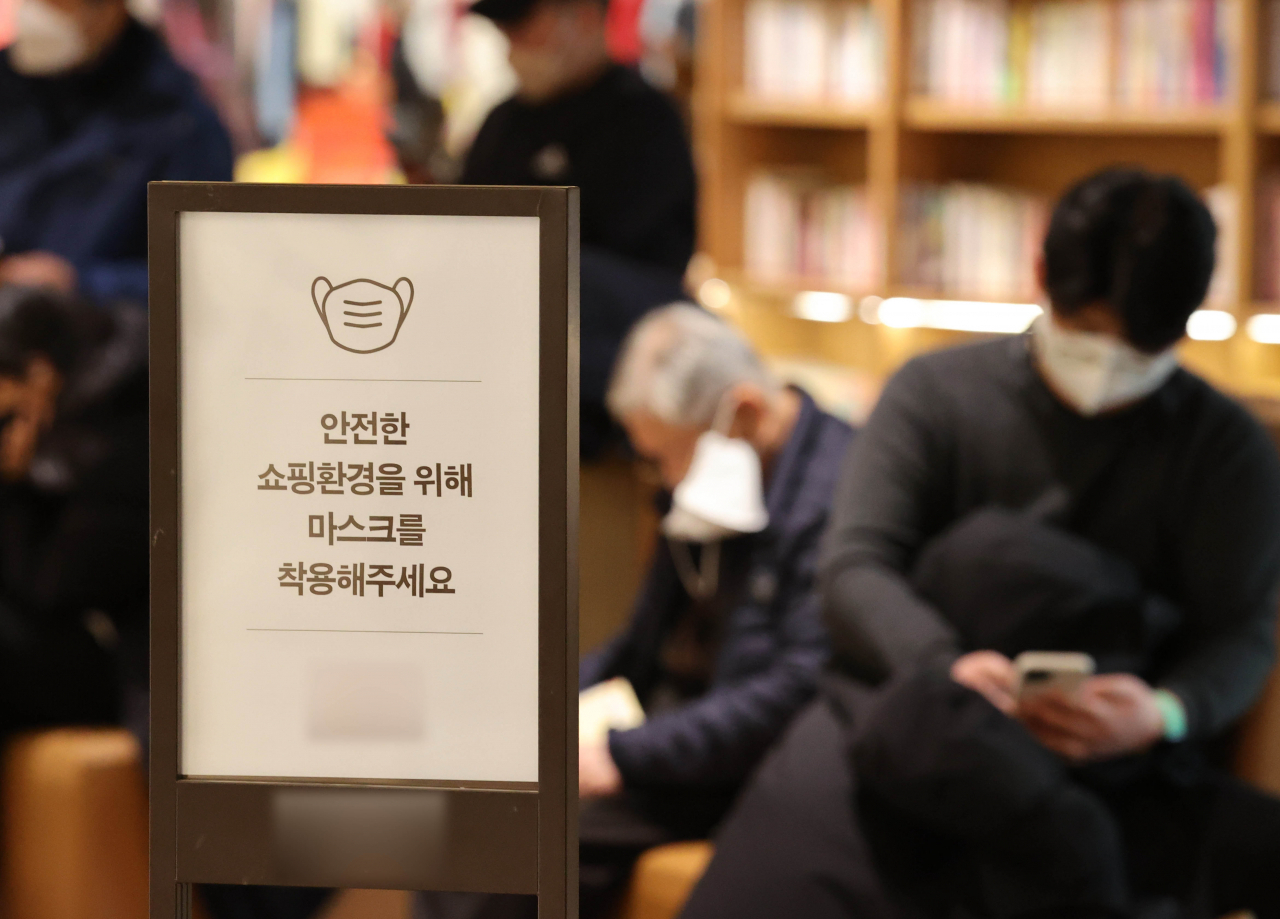 In this photograph taken on Sunday, a sign at a mall in Seoul asks visitors to keep their face masks on. (Yonhap)