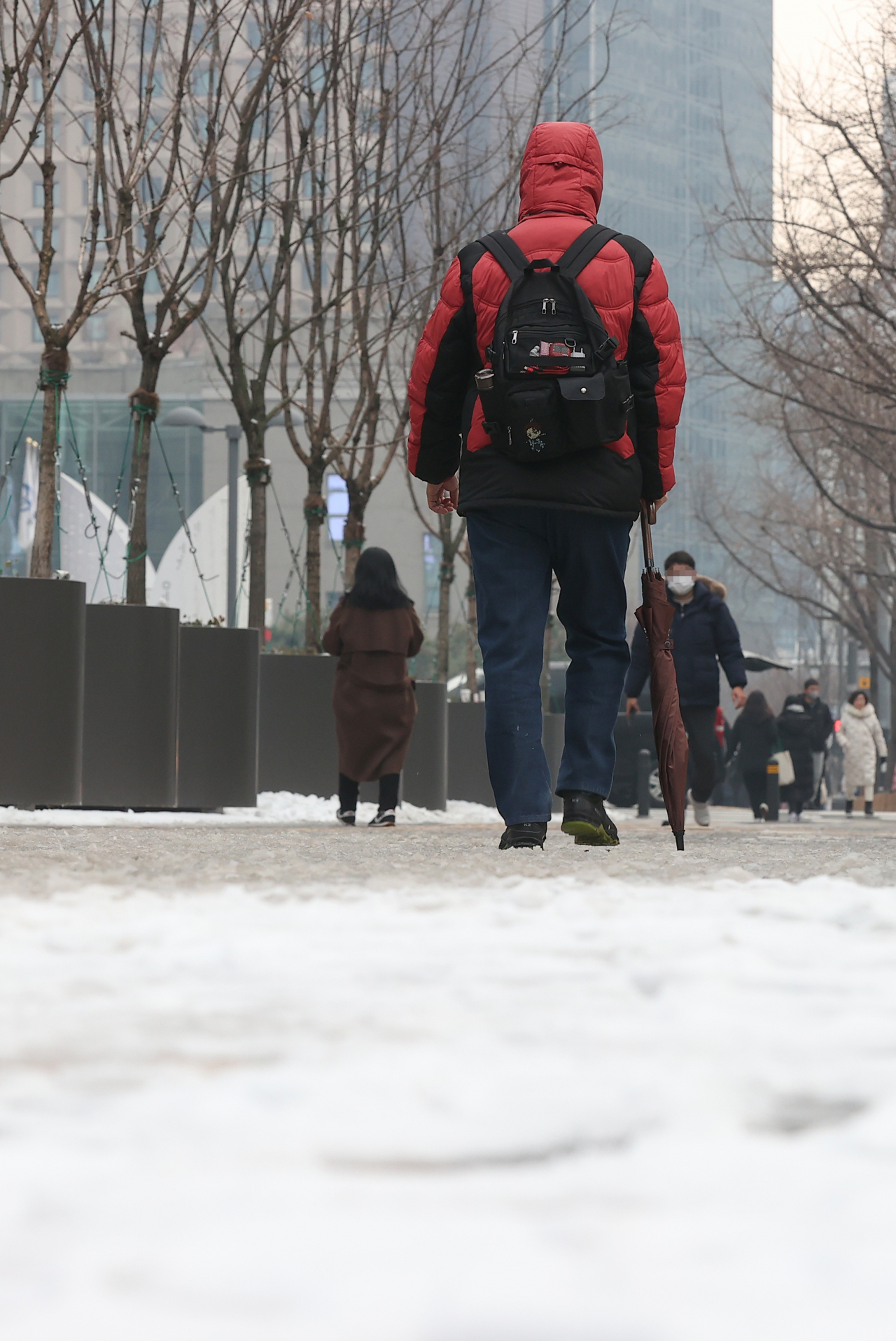 A pedestrian walks on a sidewalk covered in snow in Seoul on Wednesday.