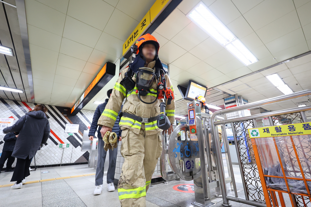 A firefighter walks inside Dongnimmun Station on Friday. (Yonhap)
