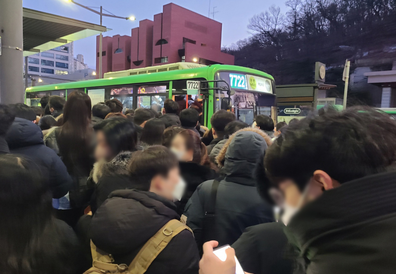 Commuters wait for a bus near Muakjae Station on Friday (Yonhap)