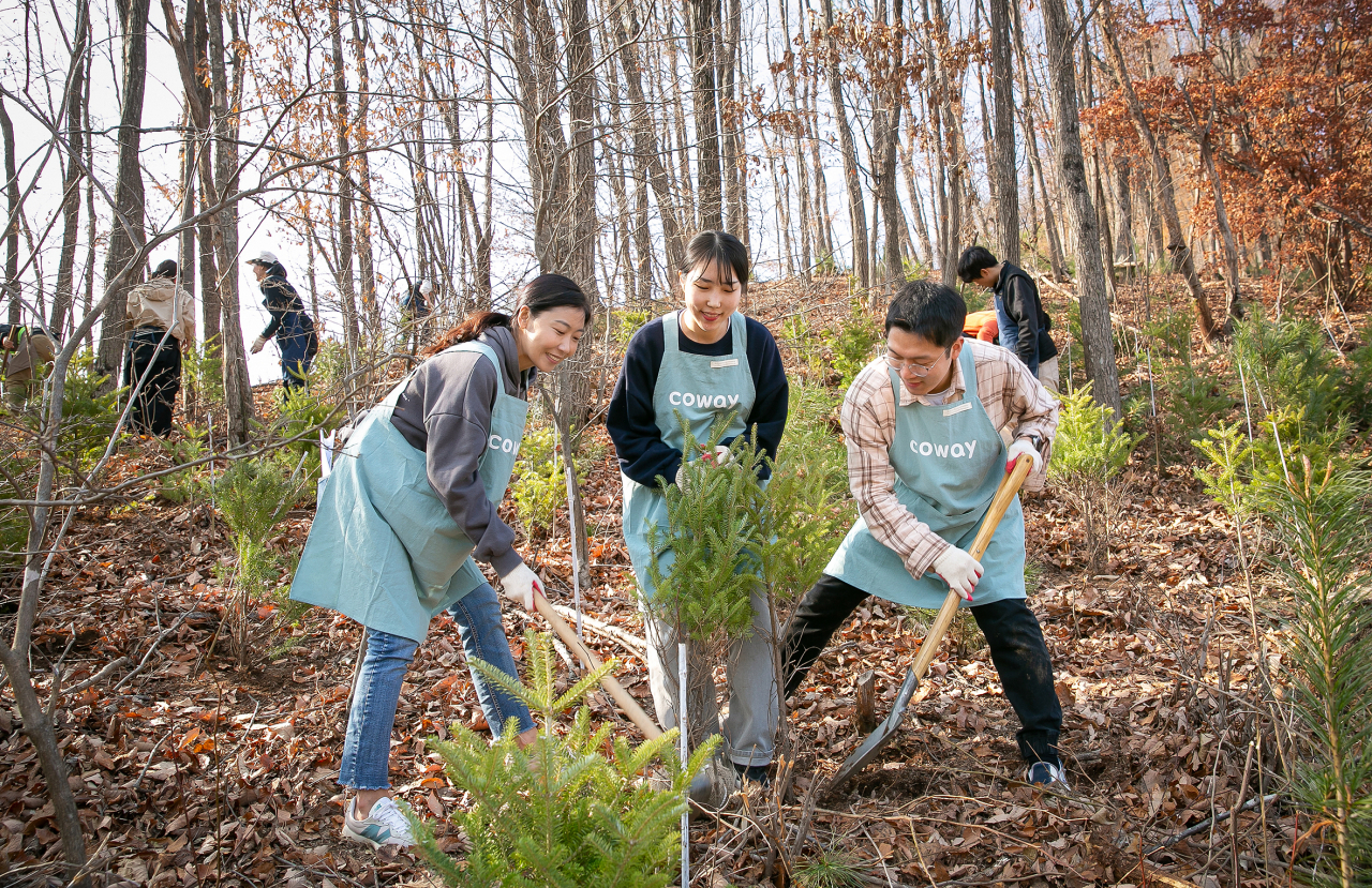 Coway employees plant a tree at Coway's 