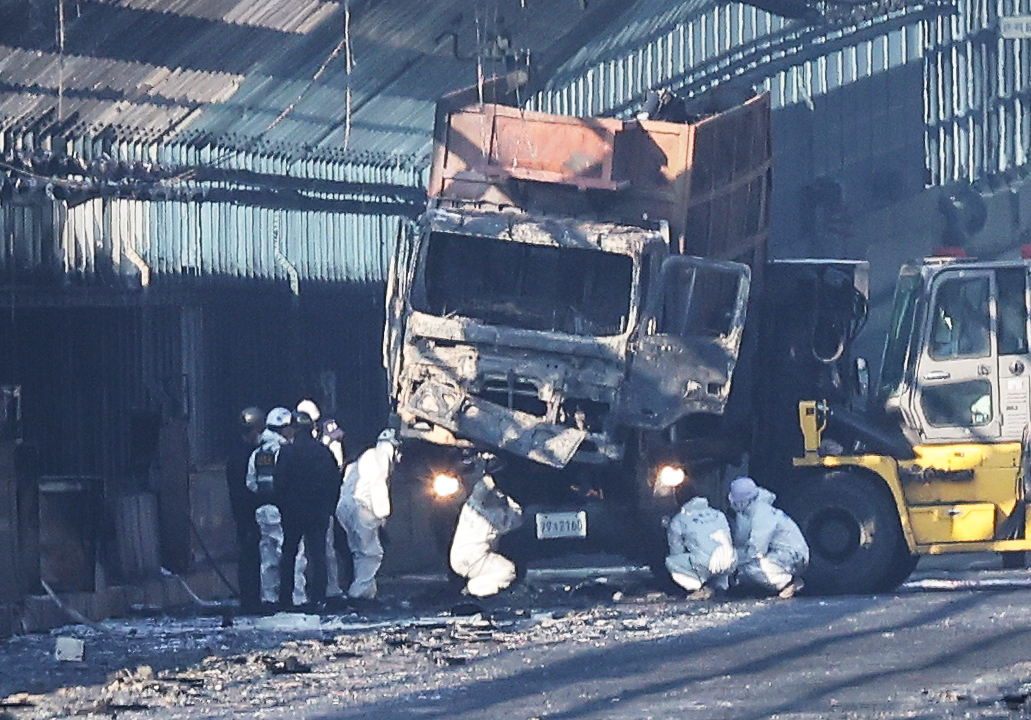 The police, fire authorities and the National Forensic Service check the truck which is assumed as the original point of ignition, Friday. (Yonhap)