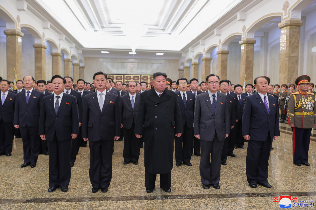 North Korean leader Kim Jong-un, at the center in the front row, visits the Kumsusan Palace of the Sun, where the bodies of state founder and his grandfather, Kim Il-sung, and his father, Kim Jong-il, are enshrined, on New Year's Day on Sunday. The state-run Korean Central News Agency reported the next day. (Yonhap)