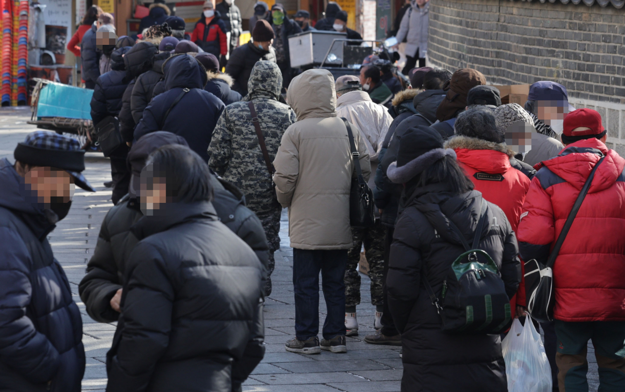 Elderly line up at a soup kitchen near Tapgol Park in Jongno-gu, central Seoul on Wednesday. (Yonhap)