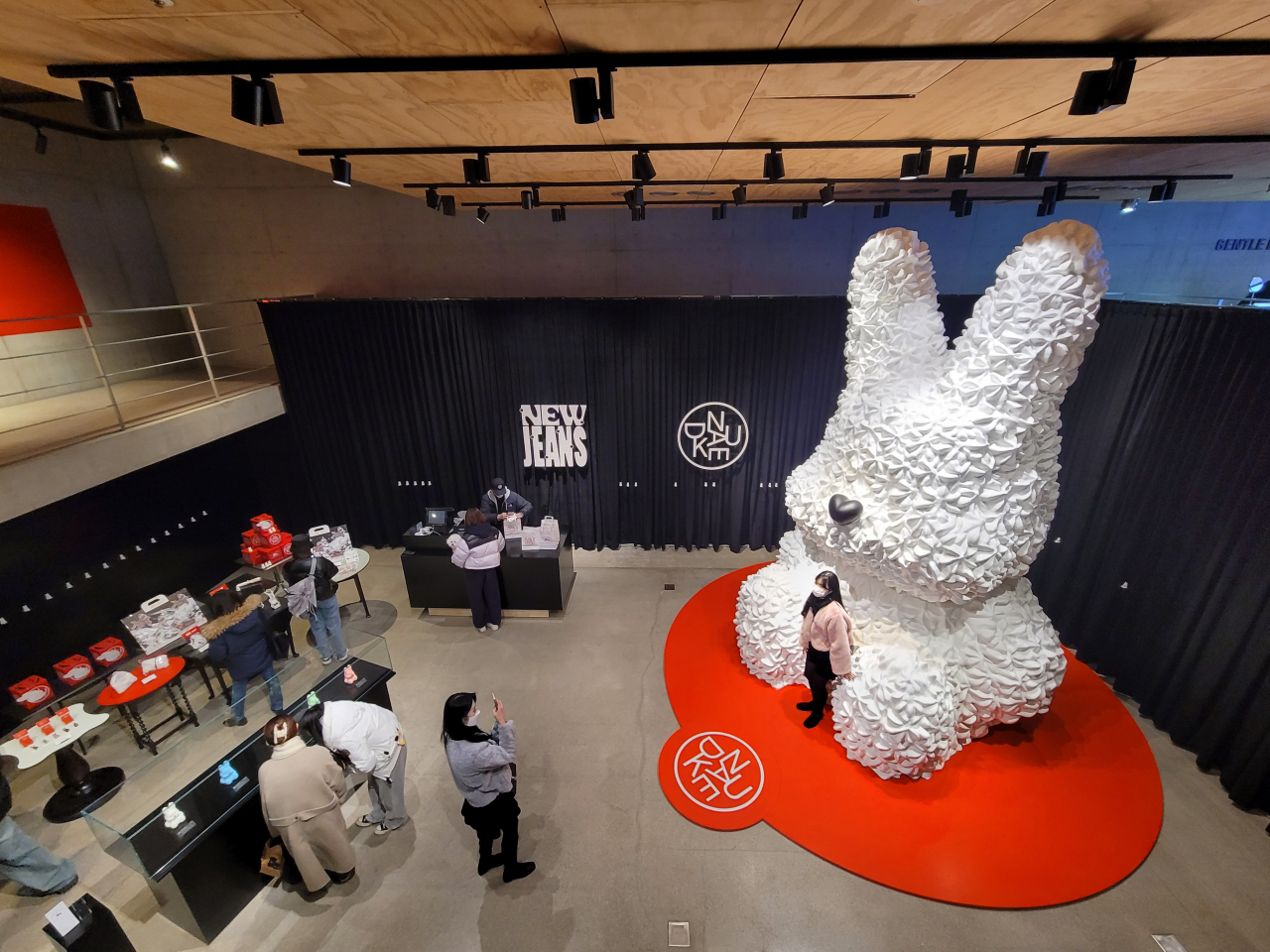 Visitors take a photograph with the rabbit installation on Tuesday at the pop-up store “OMG! NU+JEANS” in Seoul. (Park Yuna/The Korea Herald)