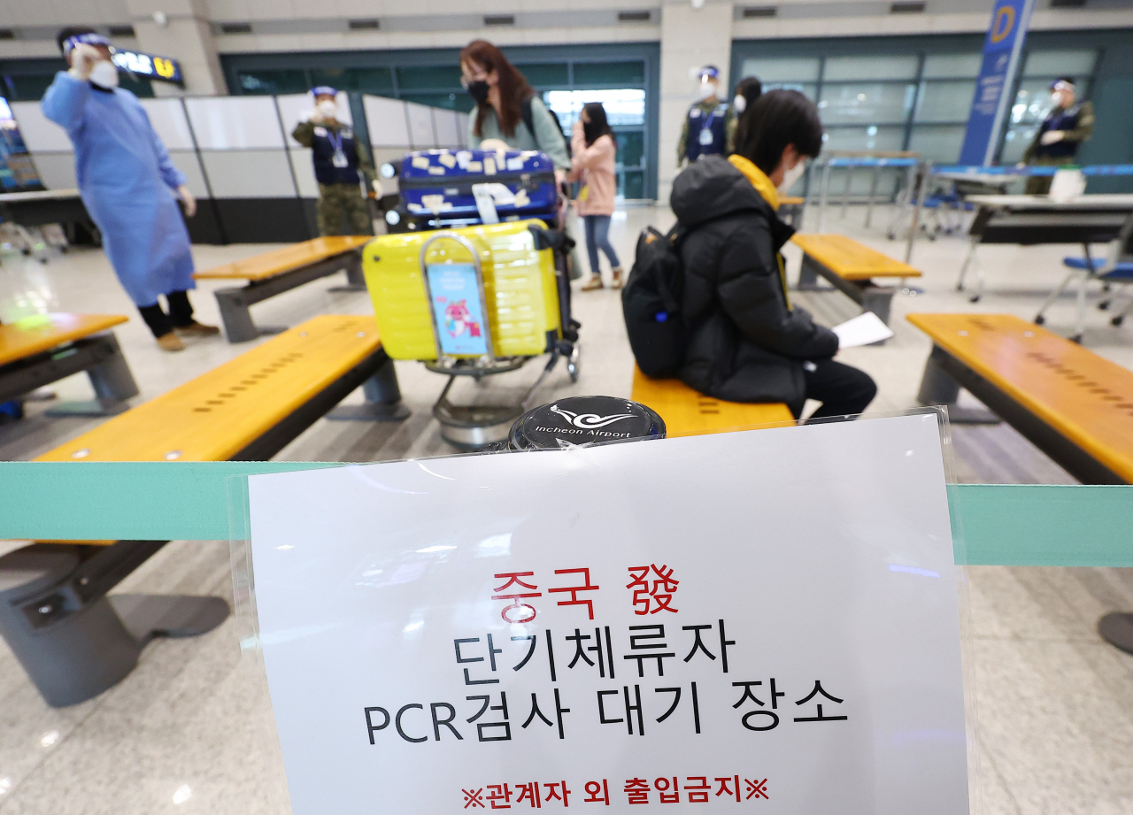 Inbound passengers from China, Hong Kong and Macao wait to take COVID-19 tests at Incheon International Airport, west of Seoul, on Sunday (Yonhap)