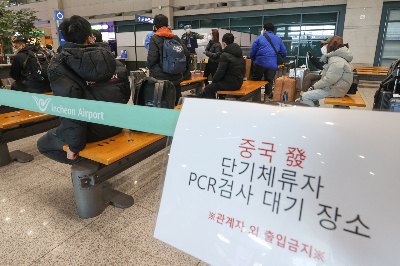 Travellers from China are waiting in line to take COVID-19 tests at Incheon International Airport, west of Seoul, on Monday. (Yonhap)