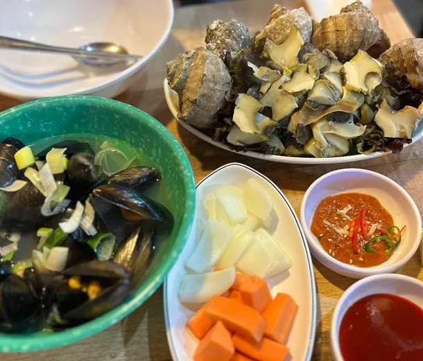 Freshly steamed top shell and mussel soup at Seochon Gyedanjip (Park Yuna/The Korea Herald)