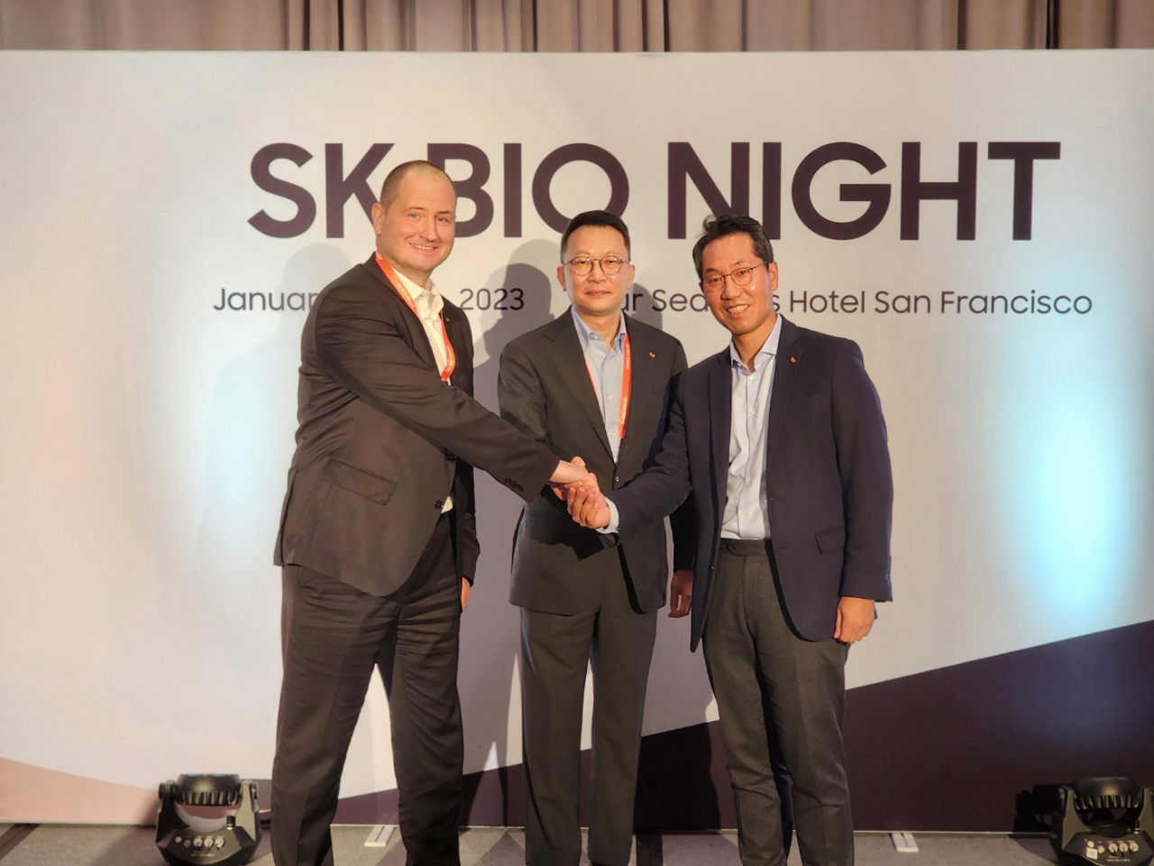 From left, SK pharmteco CEO Joerg Ahlgrimm, SK Bio Investment Center Head Kim Yeon-tae and SK biopharmaceuticals CEO Lee Dong-hoon shake hands at SK Bio Night at the Four Seasons Hotel in San Francisco on Wednesday. (SK Inc)