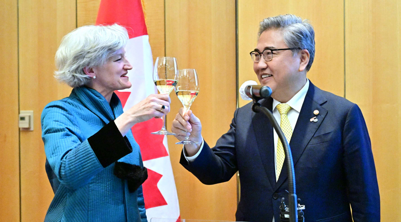 South Korean Foreign Minister Park Jin (right) and Tamara Mawhinney, Charge d' affaires at Canadian Embassy propose a toast at an event to commemorate 60th anniversary Canada-Korea relations in Jung-gu, Seoul, Thursday. (Ministry of Foreign Affairs)