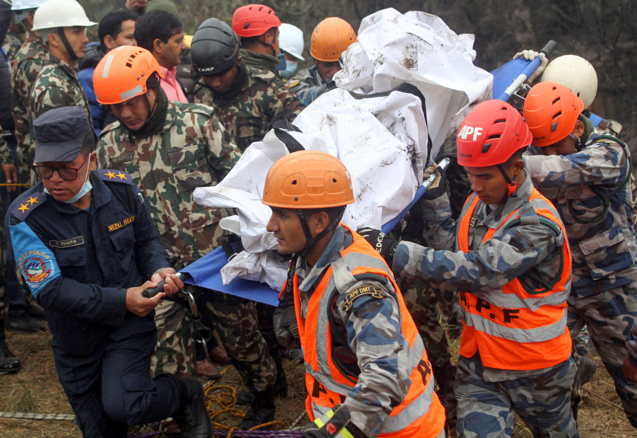 A rescue team recovers the body of a victim from the site of the plane crash of a Yeti Airlines-operated plane in Pokhara, Nepal on Jan. 16. (Reuters-Yonhap)