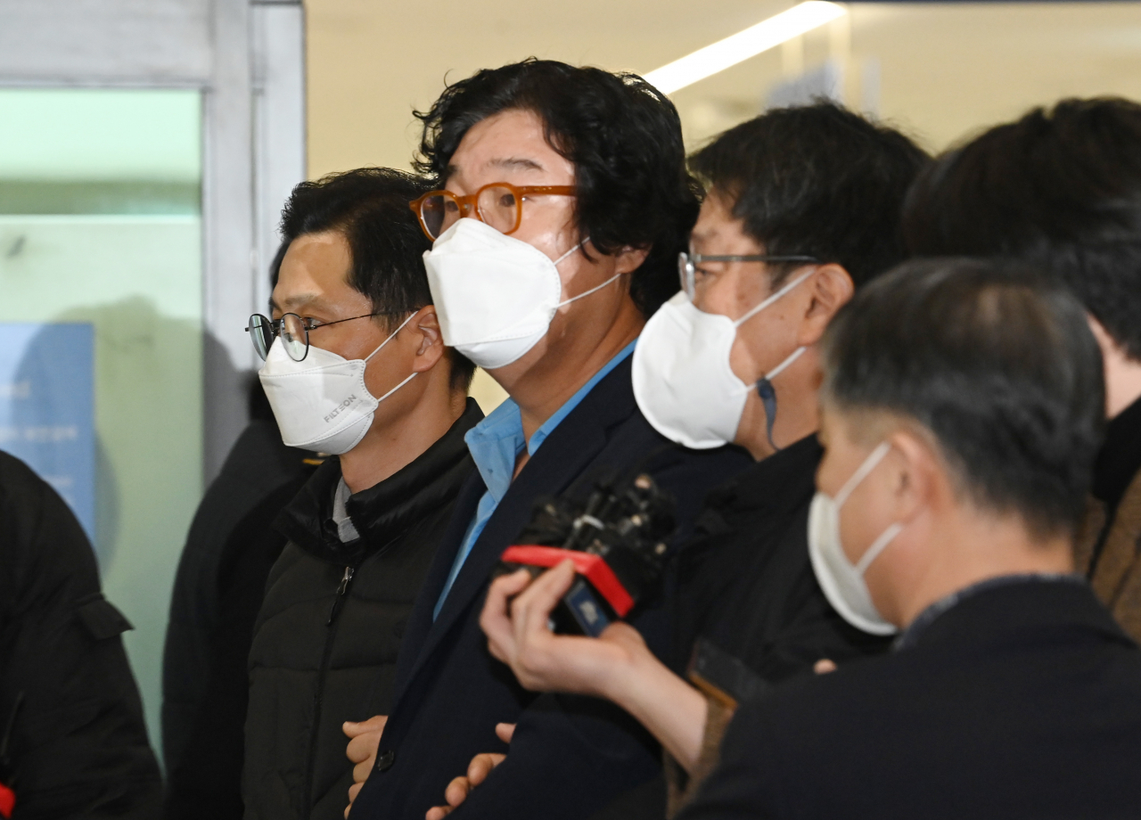 Kim Seong-tae (second from left), former chairman of underwear maker Ssangbangwool Group, is surrounded by prosecution investigators and reporters after arriving at Incheon International Airport, west of Seoul, from Thailand on Tuesday. (Yonhap)