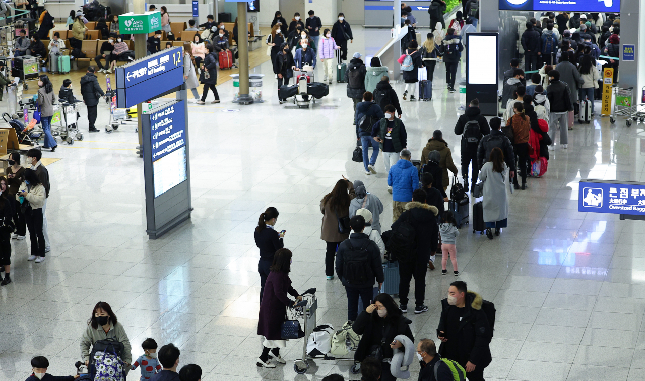 Passengers are waiting in line at Incheon International Airport Terminal 1 on Jan. 1, 2023. (Yonhap)