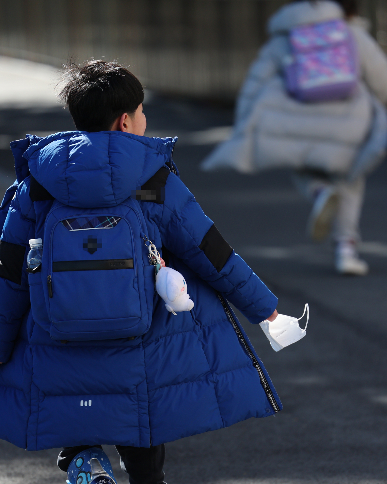 This photo taken on Wednesday shows an elementary school student in the southeastern city of Busan coming home from school with a mask in his hand. The government plans to lift a mask mandate for most indoor public spaces, including schools, next Monday. (Yonhap)
