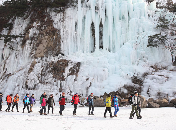 Trekkers pass a frozen waterfall in Cheorwon, Gangwon-do.  (Gangwon Snow Festa)