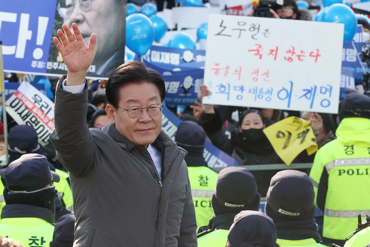 Democratic Party of Korea leader Lee Jae-myung on Saturday waves his hand to supporters before he entered a district prosecutors' office in Seoul. (Yonhap)