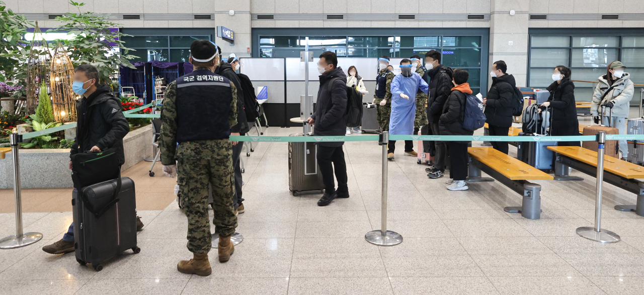 Passengers from China move to a COVID-19 testing station upon arrival at Incheon International Airport, west of Seoul, from Jan. 9. (Yonhap)