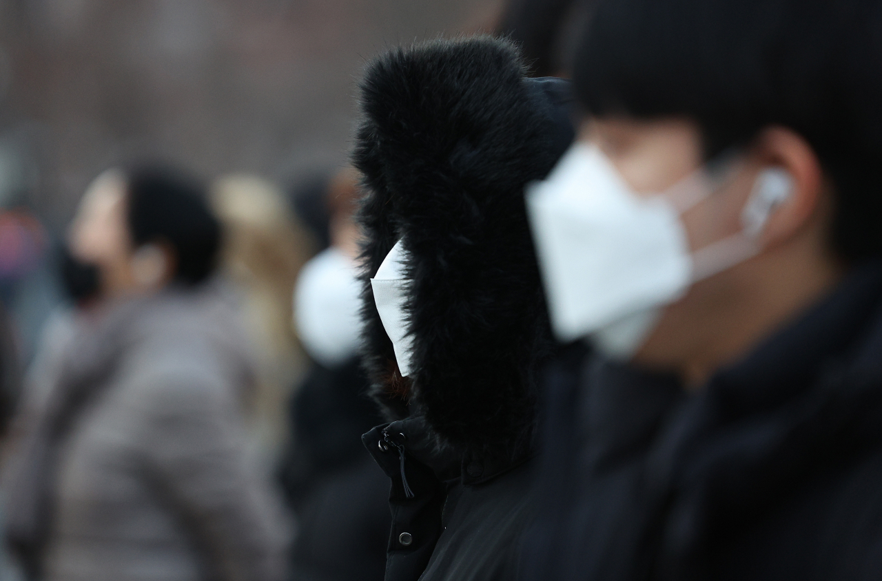 People wearing face masks wait at a crosswalk in Jongno-gu, Seoul. (Yonhap)