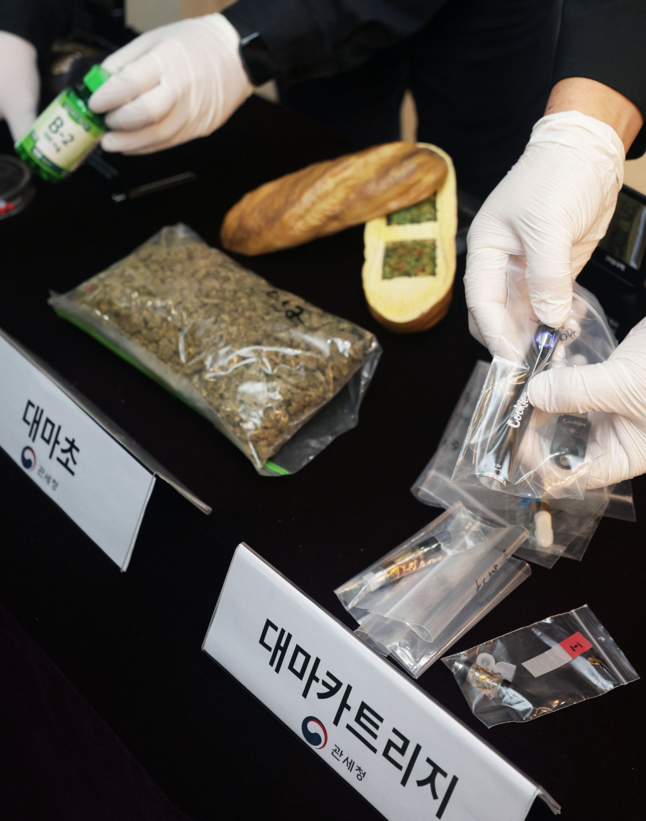 South Korean customs officers show confiscated cannabis and cannabis vape cartridges at a press briefing held at Seoul Central Customs headquarters on Thursday. (Yonhap)