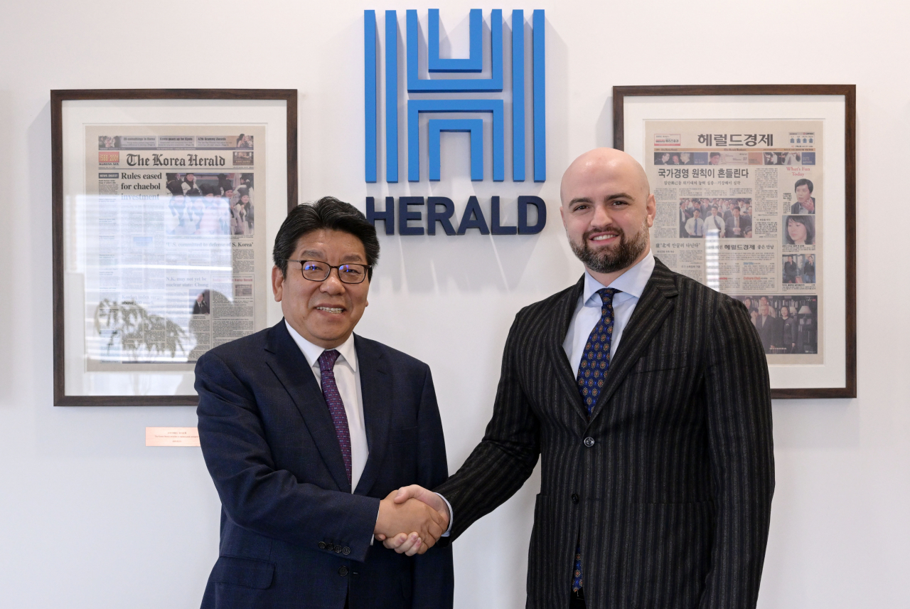 New Georgia Ambassador to Korea, Tarash Papaskua (right), and The Korea Herald CEO, Choi Jin-young, shake hands during the ambassador's courtesy visit to The Korea Herald on Tuesday. Lee Sang-sub/The Korea Herald