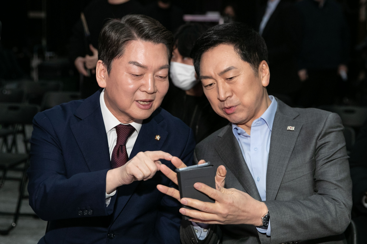 Candidates running for the chair of the ruling People Power Party -- Ahn Cheol-soo (left) and Kim Gi-hyeon -- chat with each other during an event in Seoul on Wednesday, to present their visions ahead of its leadership race scheduled for March 8. (Yonhap)