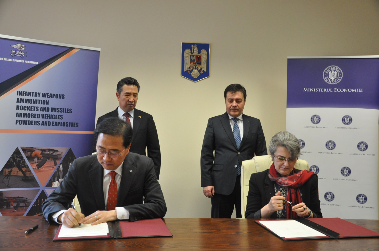 Lee Hyun-soo (left), LIG Nex1’s overseas business manager, and Florentina Micu, president of Romarm sign the memorandum of understanding at the office building of Romania's Ministry of Economy in Bucharest, Romania, Thursday. Behind them are South Korean Ambassador to Romania Rim Kap-soo (left) and Romanian Economy Minister Florin Marian Spartaru. (LIG Nex1)