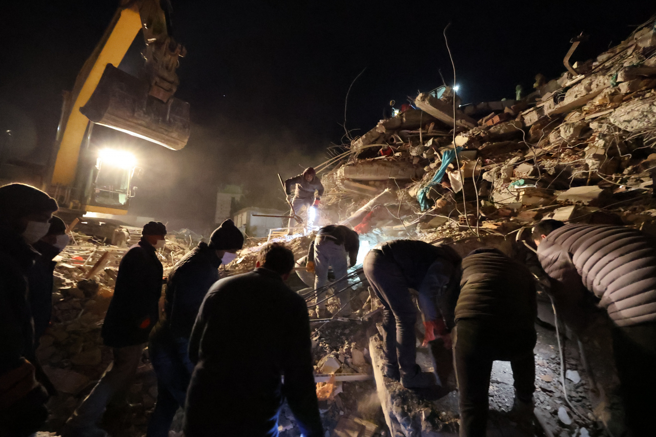 Rescuers struggle to find people trapped under rubble in Iskenderun, southeastern Turkey, on Wednesday. (Yonhap)