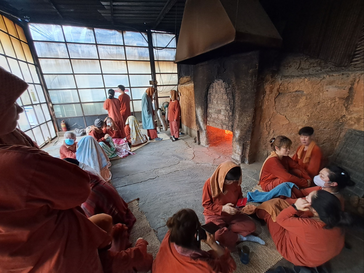 Sauna lovers sit around the fire at Jangheung Charcoal Kiln on Monday. (Lee Si-jin/The Korea Herald)