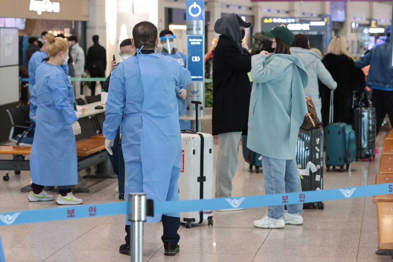 Quarantine officials guide inbound travelers from China at Incheon International Airport, west of Seoul, on Friday. (Yonhap)