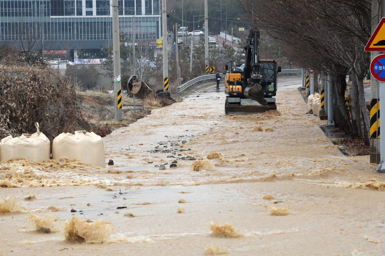 Tap water overflows into roads in the southwestern city of Gwangju on Sunday, due to a valve malfunction at a water purification plant. (Yonhap)