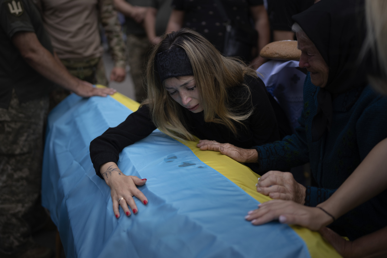 Anastasiia Okhrimenko, 26, cries over a coffin containing the body of her husband Yurii Stiahliuk, a Ukrainian serviceman who died in combat on Aug. 24 in Maryinka, Donetsk, during his funeral in Bucha, Ukraine, Wednesday, Aug. 31, 2022. (File Photo - AP)