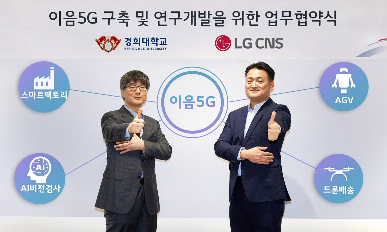 LG CNS Cloud Business head Kim Tae-hoon (right) and Lee Young-koo, Dean of College of Electronics and Information at Kyung Hee University pose after signing a memorandum of understanding. (LG CNS)