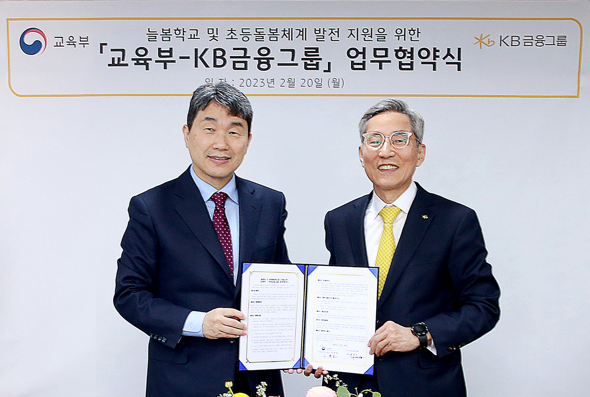 Deputy Prime Minister and Minister of Education Lee Ju-ho (left) and KB Financial Group Chairman Yoon Jong-kyoo pose for a photo in Seoul on Monday after signing an agreement for the financial group to donate 50 billion won ($38.6 million) for the ministry's advanced day care programs for elementary school students. (KB Financial Group)