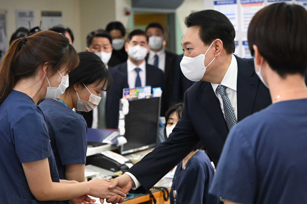 President Yoon Suk-yeol (right) meets medical staff of Seoul National University Hospital’s pediatric ward on Wednesday. (Yonhap)