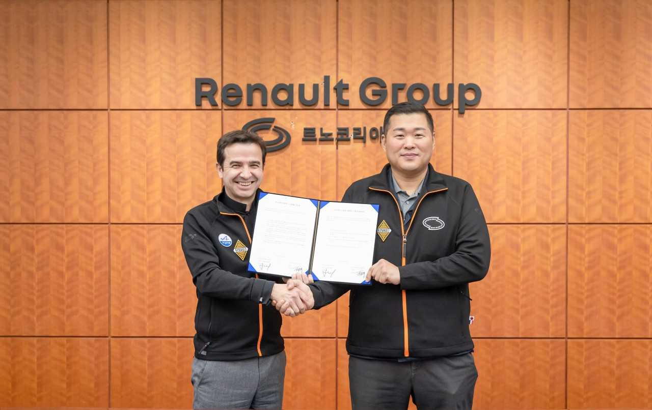 Renault Korea CEO Stephan Deblaise (left) and Kim Dong-suk, labor union leader, pose after signing an agreement to seek win-win partnership at the carmaker's Busan plant on Monday. (Renault Korea)