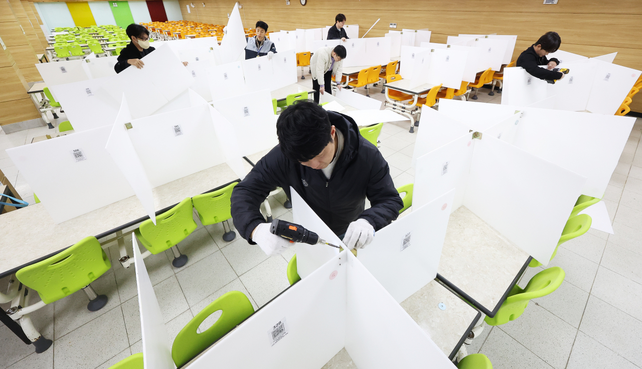 School employees remove partitions at a high school cafeteria in Suwon, Gyeonggi Province, on Monday. (Yonhap)