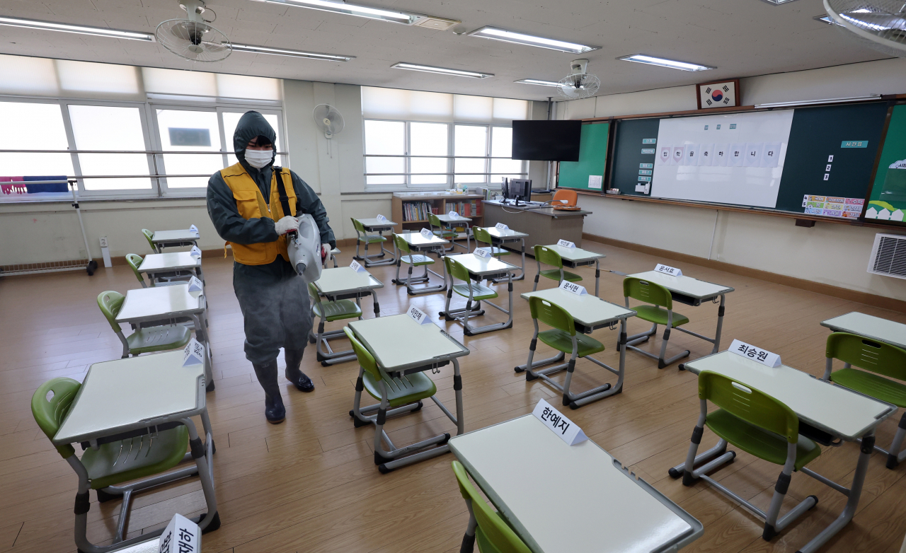 A quarantine worker sanitizes the classroom of an elementary school in Cheongju, North Chungcheong Province, in this file photo taken on last Monday (Yonhap)