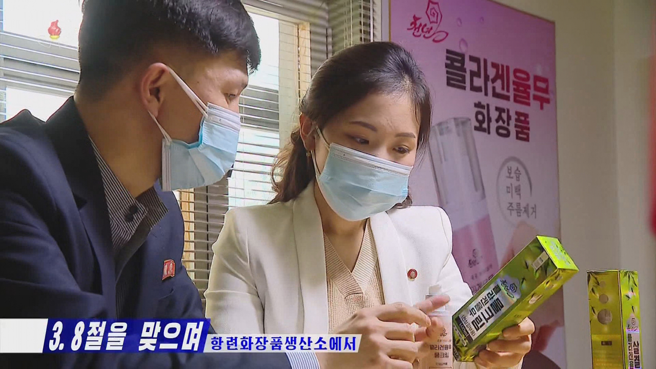 A North Korean woman looks at cosmetic products at a factory in this photo released on Wednesday. (Screencaptured from Korea Central TV)