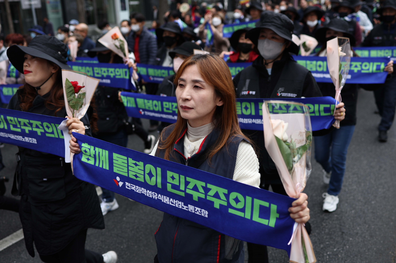 Female union members took to the streets in central Seoul on Wednesday to mark International Women's Day, carrying signs saying 